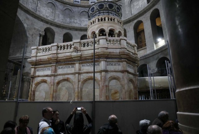 A visitor photographs the newly restored Edicule, the ancient structure housing the tomb, which according to Christian belief is where Jesus's body was anointed and buried, at the Church of the Holy Sepulchre in Jerusalem's Old City March 20, 2017. REUTERS/Ronen Zvulun