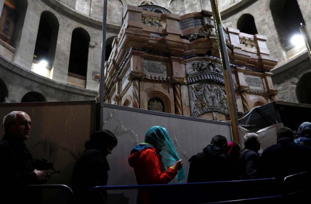 Visitors stand near the newly restored Edicule, the ancient structure housing the tomb, which according to Christian belief is where Jesus's body was anointed and buried, at the Church of the Holy Sepulchre in Jerusalem's Old City March 20, 2017. REUTERS/Ronen Zvulun