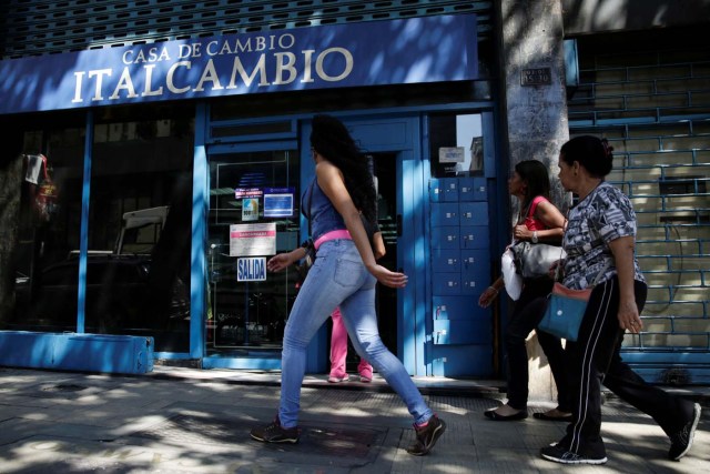 People walk past a branch of Italcambio currency exchange in Caracas, Venezuela January 20, 2017. Picture taken January 20, 2017. REUTERS/Marco Bello To match Exclusive VENEZUELA-BANKS/