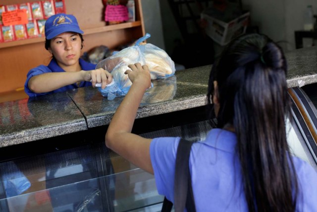A saleswoman sells bread at a bakery in Caracas, Venezuela March 17, 2017. REUTERS/Marco Bello