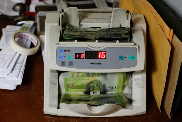 A machine counts Venezuelan bolivar notes at an office in Caracas, Venezuela March 21, 2017. REUTERS/Marco Bello