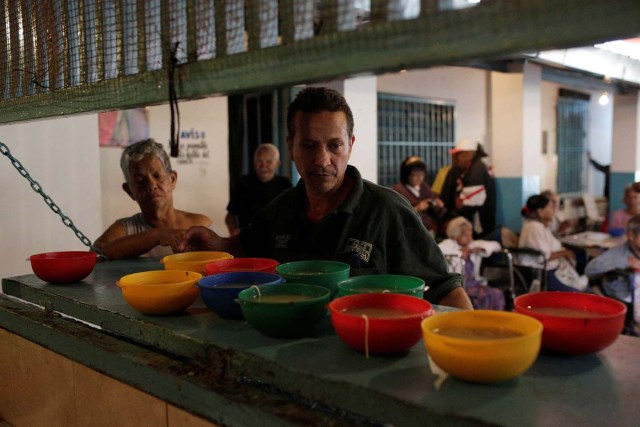 A worker waits to deliver bowls of soup donated by La Sibilla restaurant, member of the "Full Stomach, Happy Heart" (Barriga llena, corazon contento) charity, at the Mother Teresa of Calcutta nursing home, in Caracas, Venezuela February 23, 2017. Picture taken February 23, 2017. REUTERS/Marco Bello