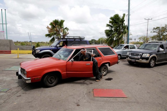 A man pushes his car after running out of gas at a gas station of Venezuelan state oil company PDVSA in Maturin, Venezuela March 23, 2017. REUTERS/Marco Bello