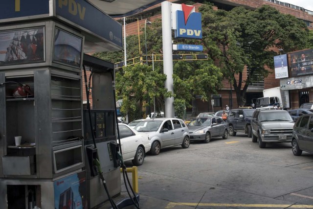 Motorists await in long lines to refuel at a gas station in Caracas, as a failure in distribution is affecting fuel supply, on March 23, 2017. / AFP PHOTO / CARLOS BECERRA