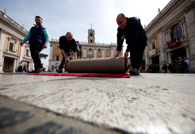Workers lay a red carpet in front of the city hall "Campidoglio" (the Capitoline hill) as preparation for the meeting of EU leaders on the 60th anniversary of the Treaty of Rome, in Rome, Italy March 24, 2017. REUTERS/Alessandro Bianchi