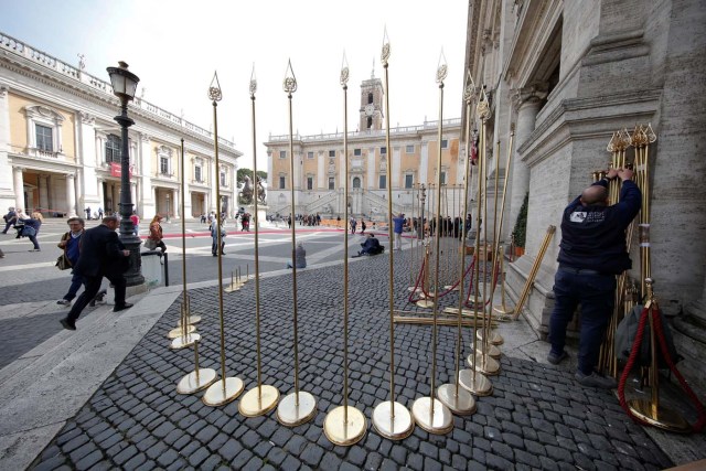 A worker installs flag poles in front of the city hall "Campidoglio" (the Capitoline hill) as preparation for the meeting of EU leaders on the 60th anniversary of the Treaty of Rome, in Rome, Italy March 24, 2017. REUTERS/Alessandro Bianchi