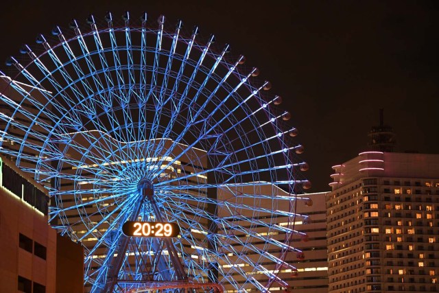 The Yokohama giant ferris wheel, Cosmo Clock 21, is seen moments before its lights were turned off for the Earth Hour environmental campaign in Yokohama on March 25, 2017. / AFP PHOTO / Toshifumi KITAMURA