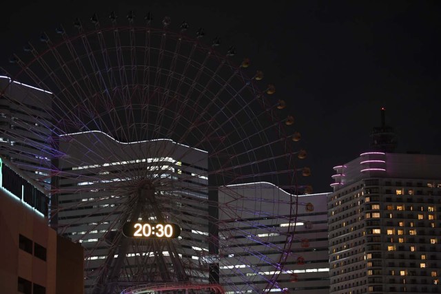 The Yokohama giant ferris wheel, Cosmo Clock 21, is seen with its lights turned off for the Earth Hour environmental campaign in Yokohama on March 25, 2017. / AFP PHOTO / Toshifumi KITAMURA