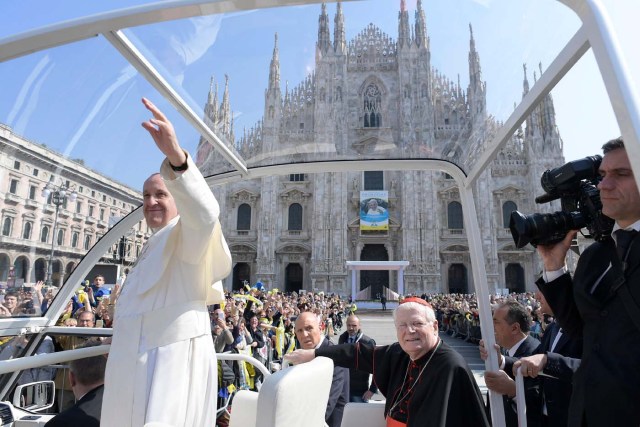 Pope Francis waves to the faithful from the popemobile as Cardinal Angelo Scola, the Archbishop of Milan, looks on, after the Angelus in Duomo Square in Milan, Italy, March 25, 2017.    Osservatore Romano/Handout via Reuters TPX IMAGES OF THE DAY - ATTENTION EDITORS - THIS IMAGE WAS PROVIDED BY A THIRD PARTY. EDITORIAL USE ONLY. NO RESALES. NO ARCHIVE.