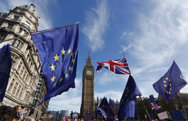 EU and Union flags fly above Parliament Square during a Unite for Europe march, in central London, Britain March 25, 2017. REUTERS/Peter Nicholls