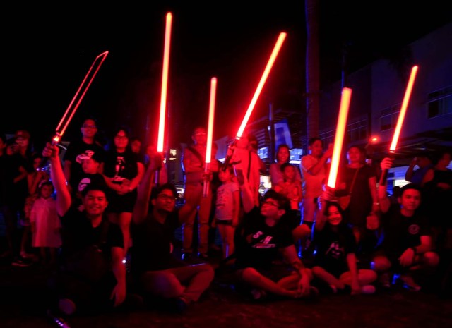 Star Wars enthusiasts raise their lightsabers as they participate in the annual Earth Hour, an hour of lights out to raise awareness on climate change, in Taguig city, metro Manila, Philippines March 25, 2017. REUTERS/Romeo Ranoco