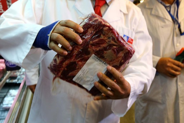 A member of the Public Health Surveillance Agency inspects a beef where the products are exposed at a supermarket after the Chilean government suspended all meat and poultry imports from Brazil, in Santiago, Chile March 23, 2017. REUTERS/Ivan Alvarado