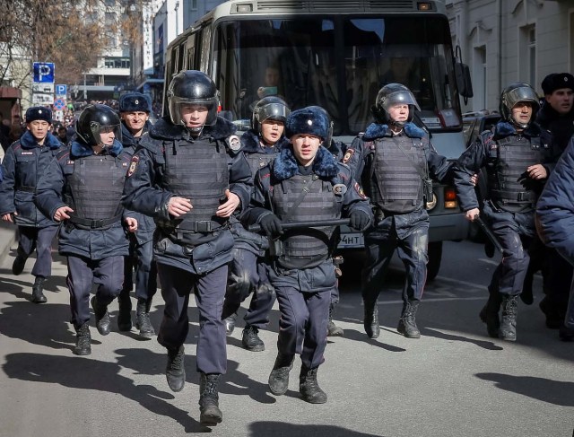 Law enforcement officers run in front of a van transporting detained anti-corruption campaigner and opposition figure Alexei Navalny during a rally in Moscow, Russia, March 26, 2017. REUTERS/Maxim Shemetov