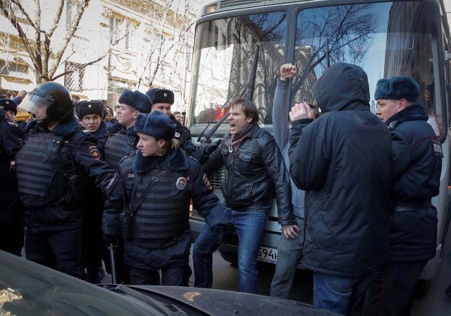 An opposition supporter (C) blocks a police van transporting detained anti-corruption campaigner and opposition figure Alexei Navalny during a rally in Moscow, Russia, March 26, 2017. REUTERS/Maxim Shemetov