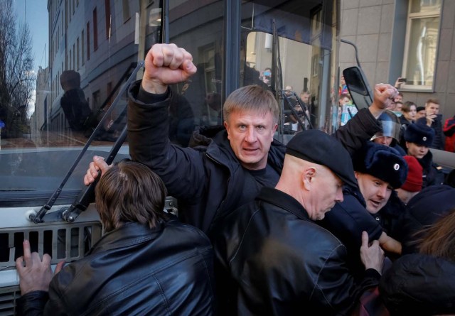 An opposition supporter gestures as he blocks a police van transporting detained anti-corruption campaigner and opposition figure Alexei Navalny during a rally in Moscow, Russia, March 26, 2017. REUTERS/Maxim Shemetov