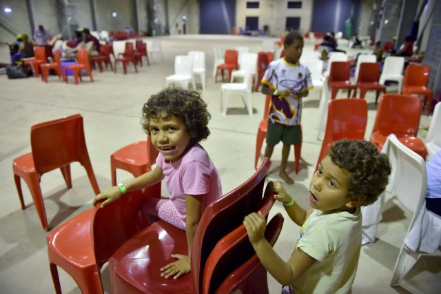 Local children play in the safety of a temporary cyclone shelter in the town of Ayr in far north Queensland on March 27, 2017. Thousands of people including tourists were evacuated on March 27, 2017 as northeast Australia braced for a powerful cyclone packing destructive winds with warnings of major structural damage and surging tides. / AFP PHOTO / PETER PARKS