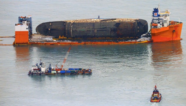 The sunken ferry Sewol sits on a semi-submersible ship during its salvage operations at the sea off Jindo, South Korea, March 26, 2017. Yonhap via REUTERS ATTENTION EDITORS - THIS IMAGE HAS BEEN SUPPLIED BY A THIRD PARTY. SOUTH KOREA OUT. FOR EDITORIAL USE ONLY. NO RESALES. NO ARCHIVE.