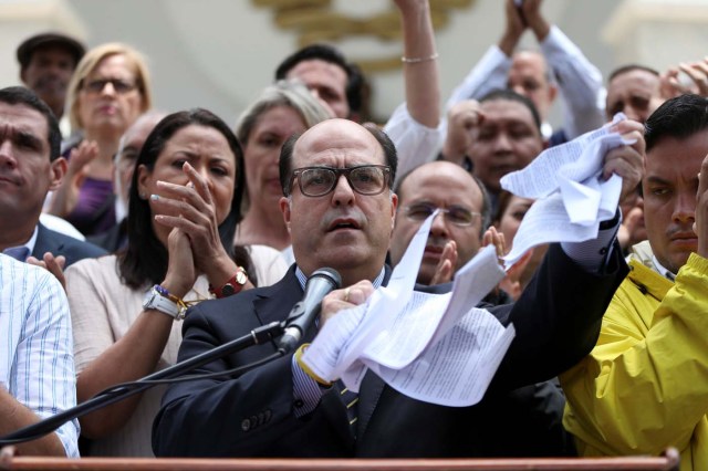 Julio Borges (C), President of the National Assembly and deputy of the Venezuelan coalition of opposition parties (MUD), tears a copy of a sentence of the Venezuela's Supreme Court during a news conference in Caracas, Venezuela March 30, 2017. REUTERS/Carlos Garcia Rawlins