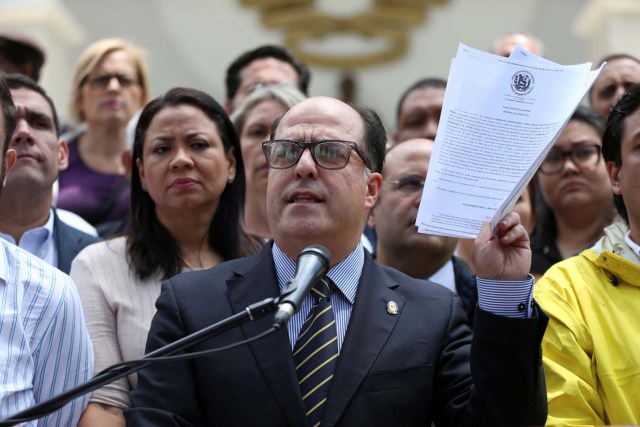 Julio Borges (C), President of the National Assembly and deputy of the Venezuelan coalition of opposition parties (MUD), holds a copy of a sentence of the Venezuela's Supreme Court during a news conference in Caracas, Venezuela March 30, 2017. REUTERS/Carlos Garcia Rawlins