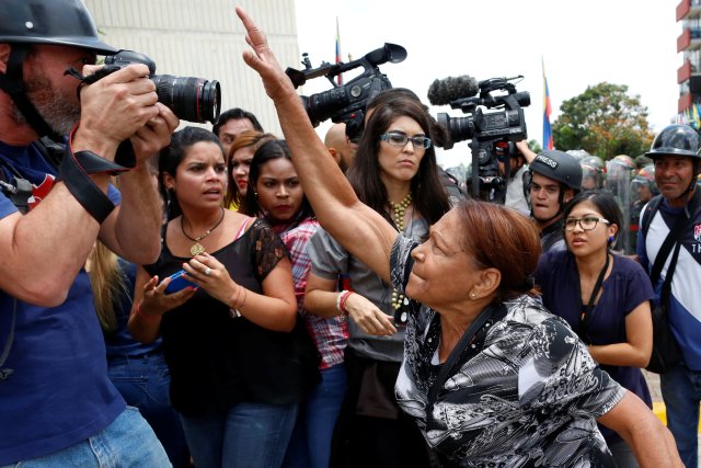 A supporter of Venezuela's President Nicolas Maduro tries to take the camera of a photographer away, during clashes with opposition supporters outside the Supreme Court of Justice (TSJ) in Caracas