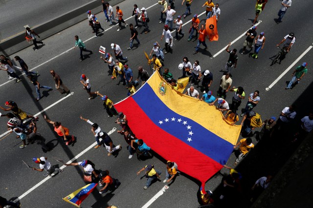Opposition supporters holding a Venezuelan flag  protest against Venezuela's President Nicolas Maduro's government during a rally in Caracas, Venezuela April 1, 2017.  REUTERS/Carlos Garcia Rawlins
