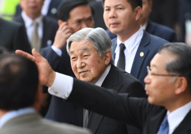 Japan's Emperor Akihito (C) flanked by security guards and Empress Michiko (not pictured) arrive at Phu Bai airport in the central city of Hue as they prepare to departure for Thailand, March 5, 2017. REUTERS/Hoang Dinh Nam