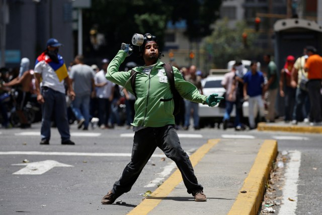 A demonstrator throws a stone during clashes with security forces during an opposition rally in Caracas, Venezuela April 4, 2017. REUTERS/Carlos Garcia Rawlins
