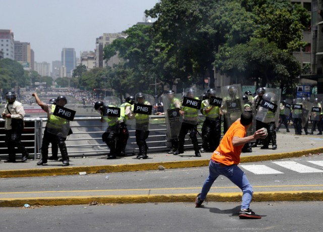 A demonstrator throws a stone towards policemen during clashes with security forces during an opposition rally in Caracas, Venezuela, April 4, 2017. REUTERS/Marco Bello