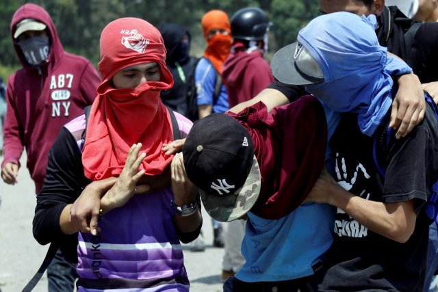 Manifestantes afectados por los gases lacrimógenos. REUTERS/Carlos Eduardo Ramirez
