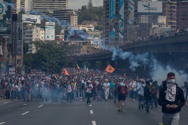 CAR01. CARACAS (VENEZUELA), 06/04/2017 - Un grupo de personas participa en una manifestación de opositores al gobierno de Nicolás Maduro hoy, jueves 6 de abril de 2017, en Caracas (Venezuela). La Policía Nacional Bolivariana (PNB) dispersó hoy con gases lacrimógenos y agua una marcha opositora en Caracas que pretendía llegar hasta la Defensoría del Pueblo para pedir su respaldo al proceso iniciado por el Parlamento contra siete magistrados del Tribunal Supremo de Justicia (TSJ). EFE/MIGUEL GUTIERREZ