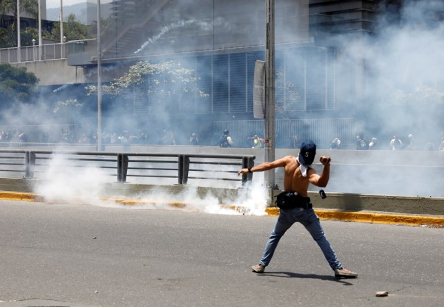 A demonstrator throws stones during clashes with the police during an opposition rally in Caracas, Venezuela, April 8, 2017. REUTERS/Carlos Garcia Rawlins