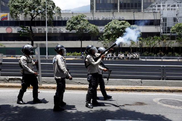 REFILE - CLARIFYING CAPTIONRiot police offcer fires a tear gas canister during an opposition rally in Caracas, Venezuela, April 8, 2017. REUTERS/Carlos Garcia Rawlins