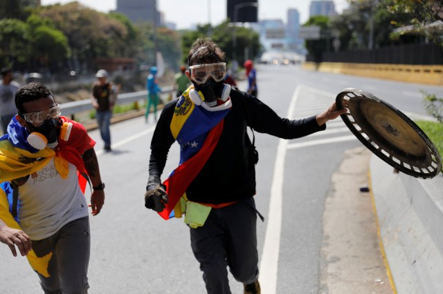 Demonstrators walk away after clashing with the riot police during a rally in Caracas, Venezuela, April 8, 2017. REUTERS/Carlos Garcia Rawlins
