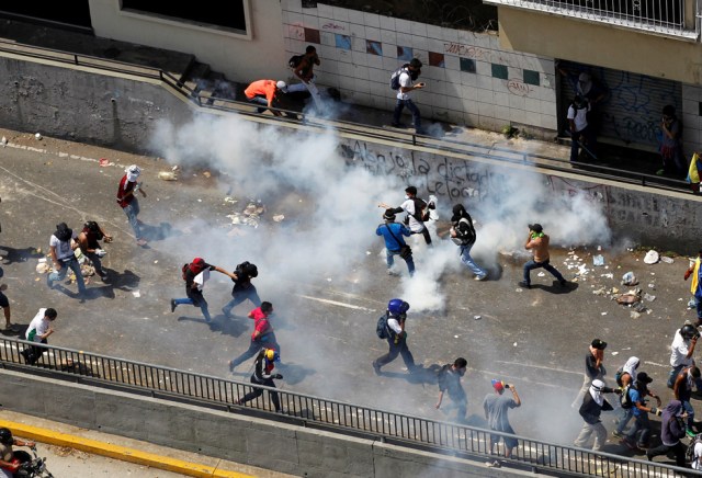 Demonstrators react during clashes with the riot police during a rally in Caracas, Venezuela, April 8, 2017. REUTERS/Christian Veron