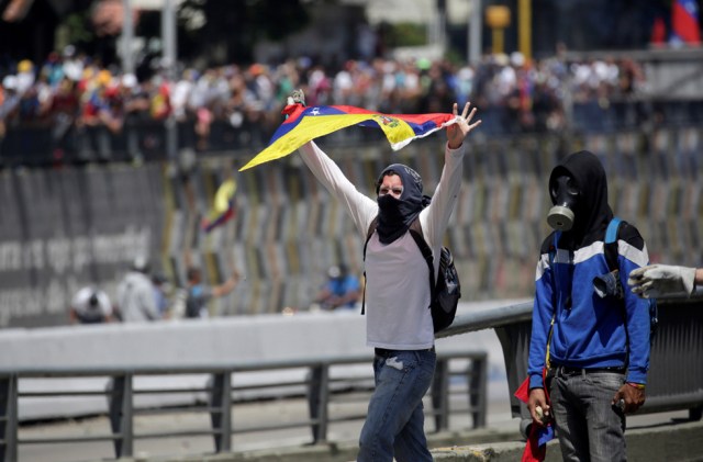 Demonstrators react during clashes with riot police during a rally in Caracas, Venezuela, April 8, 2017. REUTERS/Marco Bello