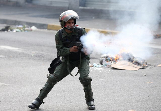 A riot police officer fires tear gas while clashing with demonstrators during a rally in Caracas, Venezuela, April 8, 2017. REUTERS/Carlos Garcia Rawlins