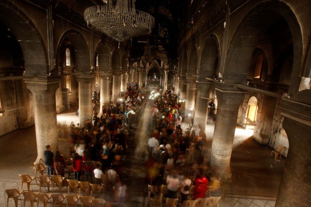 Iraqis attend the first Palm Sunday procession in the burnt out main church of the Christian city of Qaraqosh since Iraqi forces retook it from from Islamic States militants, Iraq April 9, 2017. REUTERS/Suhaib  Salem