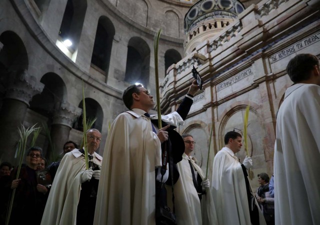 A Christian worshipper takes a picture during a Palm Sunday ceremony in the Church of the Holy Sepulchre in Jerusalem's Old City April 9, 2017. REUTERS/Ammar Awad
