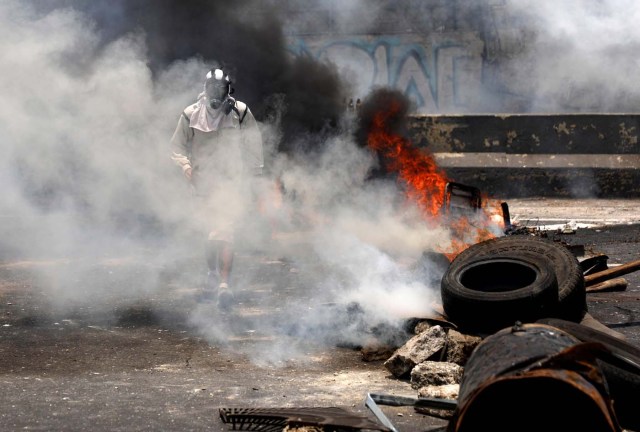 A demonstrator walks near a fire barricade at a rally against Venezuela's President Nicolas Maduro's government in Caracas, Venezuela, April 10, 2017. REUTERS/Carlos Garcia Rawlins TPX IMAGES OF THE DAY