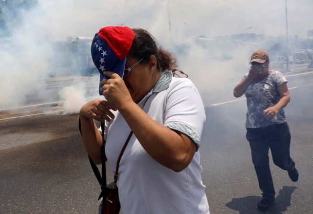 People run away from tear gas during a rally against Venezuela's President Nicolas Maduro's government in Caracas, Venezuela April 10, 2017. REUTERS/Carlos Garcia Rawlins