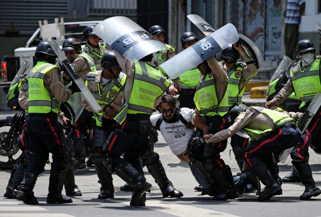 A demonstrator is arrested by riot police while rallying against Venezuela's President Nicolas Maduro's government in Caracas