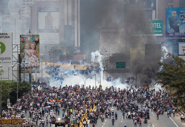 Policías antidisturbios y opositores al Gobierno de Nicolás Maduro enfrentados durante una manifestación en Caracas, abr 10, 2017. Miles de simpatizantes de la oposición venezolana volvieron el lunes a las calles del país petrolero para protestar contra el presidente Nicolás Maduro, al que acusan de haber desvirtuado su gobierno convirtiéndolo en una dictadura. REUTERS/Christian Veron