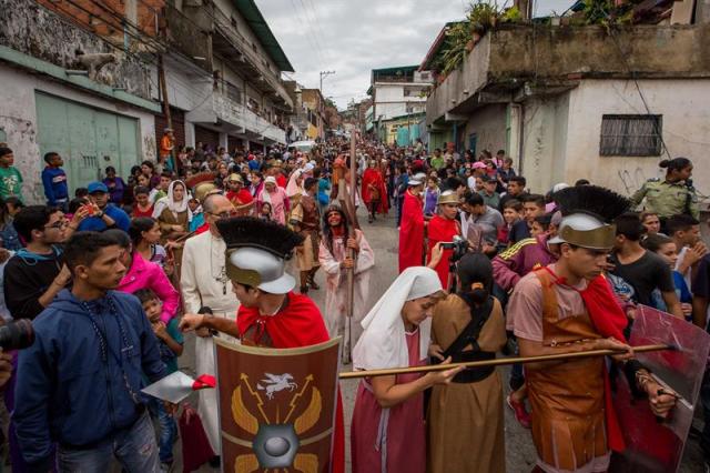 Un grupo de personas participa en la representación del viacrucis hoy, viernes 14 de abril de 2017, por las calles del barrio Petare en Caracas (Venezuela). EFE/MIGUEL GUTIÉRREZ