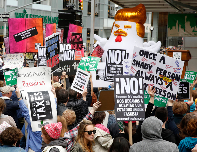 JSX03. New York (United States), 15/04/2017.- Protesters hold up signs during a Tax Day Protest March outside Bryant Park in New York, New York , USA, 15 April 2017. The protest will march up to Trump Tower on 5th Avenue. (Protestas, Nueva York, Estados Unidos) EFE/EPA/JASON SZENES