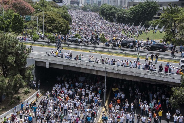 Opposition demonstrators march against the government of Venezuelan President Nicolas Maduro, in Caracas, on April 19, 2017. Venezuelans took to the streets Wednesday for massive demonstrations for and against President Nicolas Maduro, whose push to tighten his grip on power has triggered deadly unrest that has escalated the country's political and economic crisis. / AFP PHOTO / Carlos Becerra