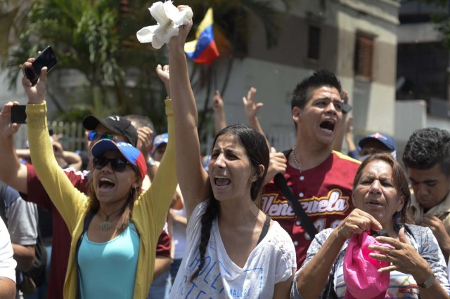 Demonstrators march against Venezuelan President Nicolas Maduro, in Caracas on April 20, 2017. Venezuelan riot police fired tear gas Thursday at groups of protesters seeking to oust President Nicolas Maduro, who have vowed new mass marches after a day of deadly unrest. Police in western Caracas broke up scores of opposition protesters trying to join a larger march, though there was no immediate repeat of Wednesday's violent clashes, which left three people dead. / AFP PHOTO / Federico PARRA