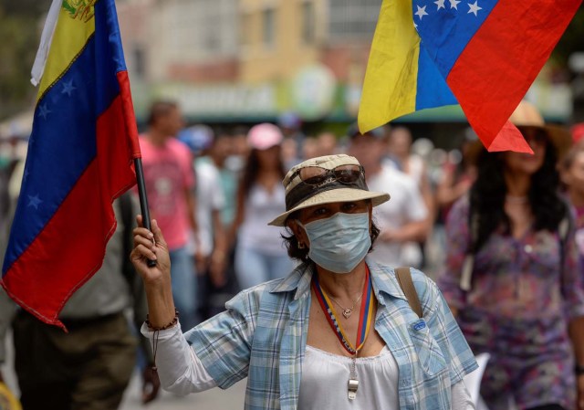 A woman demonstrates during a march against Venezuelan President Nicolas Maduro, in Caracas on April 20, 2017. Venezuelan riot police fired tear gas Thursday at groups of protesters seeking to oust President Nicolas Maduro, who have vowed new mass marches after a day of deadly unrest. Police in western Caracas broke up scores of opposition protesters trying to join a larger march, though there was no immediate repeat of Wednesday's violent clashes, which left three people dead. / AFP PHOTO / Federico PARRA