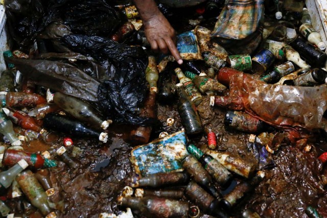 A worker looks for valuables among the damaged goods in a supermarket, after it was looted in Caracas, Venezuela April 21, 2017. REUTERS/Carlos Garcia Rawlins