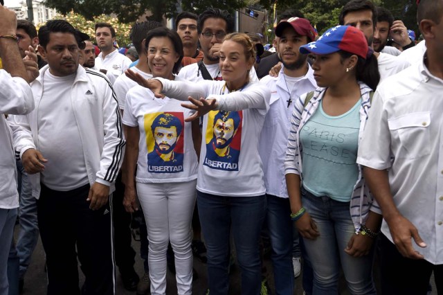 Lilian Tintori (C), wife of jailed Venezuelan opposition leader Leopoldo Lopezand Lopez's mother, Maria Antonieta de Lopez (2nd-L) prepare to take part in a march towards the Catholic Church's episcopal seats nationwide, in Caracas, on April 22, 2017. Venezuelans gathered Saturday for "silent marches" against President Nicolas Maduro, a test of his government's tolerance for peaceful protests after three weeks of violent unrest that has left 20 people dead. / AFP PHOTO / JUAN BARRETO