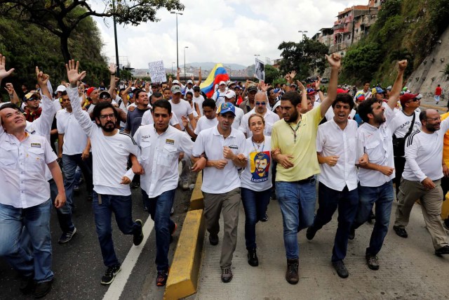 Venezuelan opposition leader and Governor of Miranda state Henrique Capriles (4th L), Lilian Tintori, (5th R), wife of jailed opposition leader Leopoldo Lopez, walk together with lawmakers as they take part in a rally to honour victims of violence during a protest against Venezuela's President Nicolas Maduro's government in Caracas, Venezuela, April 22, 2017. REUTERS/Carlos Garcia Rawlins